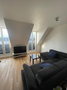 a living room with a couch and a flat screen tv at Paris Centre Place Saint Michel in Paris