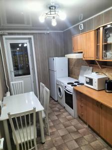 阿斯克卡明諾戈斯克的住宿－APARTMENT at REPUBLIC SQUARE，厨房配有桌子和白色冰箱。