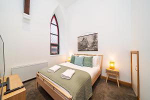 Schlafzimmer mit einem Bett und einem Fenster in der Unterkunft The Church Front in Montrose