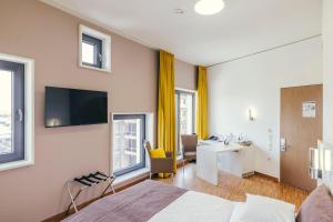 ein Hotelzimmer mit einem Bett, einem Schreibtisch und einem Fenster in der Unterkunft GZT Das Gästehaus in Tübingen