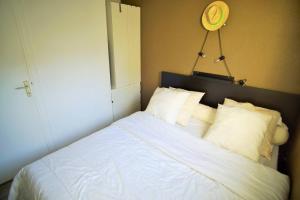 een slaapkamer met een bed met witte lakens en kussens bij Bel appartement moderne, tout à pied in Saint-Mandrier-sur-Mer