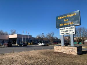 um sinal em frente a um parque de estacionamento em Albany Airport Inn em Albany