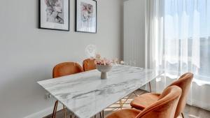 comedor con mesa de mármol y sillas en Lion Apartments - SCALA City Center Apartments&Studio IIIC en Gdansk