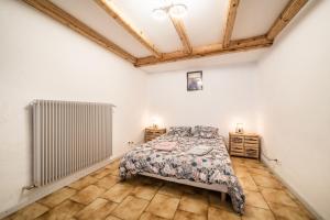 1 dormitorio con cama y radiador en Appartement proche station - 7 pers, en Châtillon-sur-Cluses