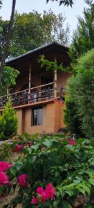 a house with a balcony with pink flowers at ANGELSNESTMOUNTAINVIEW in Chekadi