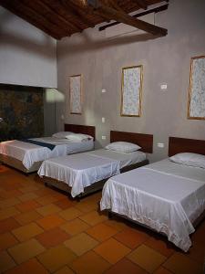 a room with three beds in a room with at EcoHotel Inka Minka in Santa Marta