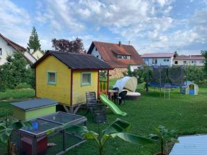 een achtertuin met een speelhuis en een speeltuin bij Ferienwohnung Ingrid in Kressbronn am Bodensee
