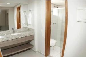 ein Badezimmer mit Dusche, Waschbecken und Toilette in der Unterkunft Atrium Thermas Residence Service in Caldas Novas