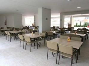 ein Esszimmer mit Tischen und Stühlen in einem Gebäude in der Unterkunft Atrium Thermas Residence Service in Caldas Novas