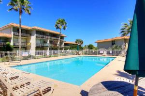 a swimming pool with lounge chairs and a hotel at A Salty Day Getaway at Sea Sands Condominiums in Port Aransas