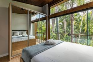 um quarto com uma cama e uma grande janela em Recanto Natureza em Florianópolis