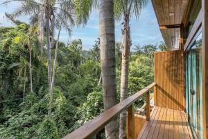 uma passagem de madeira que leva a uma casa com palmeiras em Recanto Natureza em Florianópolis