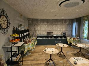 a restaurant with tables and a kitchen with a clock at Hotel Euro in Castegnato