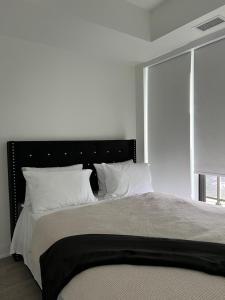 a bedroom with a large bed with white pillows at Luxury Lakefront Condo in Toronto