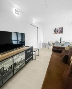 a living room with a large television and a couch at Refuge d'Anjou in Angers