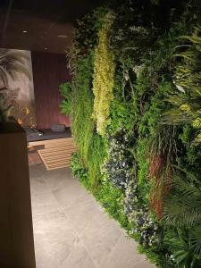 MM Boutique Hotel في مدينة بورغاس: جدار أخضر عليه نباتات وزهور