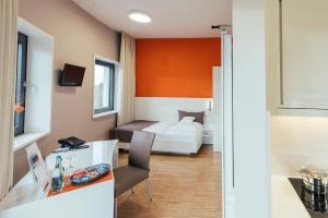 a hotel room with a bed and a desk with a chair at GZT Das Gästehaus in Tübingen