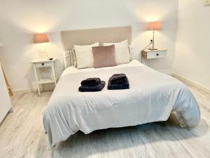 een slaapkamer met een wit bed en 2 handdoeken bij El patio de Tendillas in Córdoba