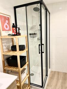 een douche met een glazen deur in de badkamer bij El patio de Tendillas in Córdoba