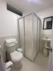 La salle de bains blanche est pourvue de toilettes et d'un lavabo. dans l'établissement Apto caney 402, à Cali