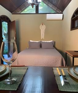 een slaapkamer met een bed en een tafel met borden en glazen bij KORU Cabana - Paz & Romance in Petrópolis