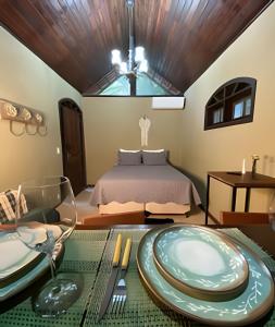 a bedroom with a bed and a table with plates on it at Cabana no meio do Vale! (Itaipava-Araras) in Petrópolis