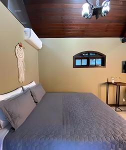 een slaapkamer met een bed en een plafond bij KORU Cabana - Paz & Romance in Petrópolis