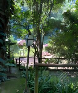 een lamp in een tuin met een tafel en een boom bij KORU Cabana - Paz & Romance in Petrópolis