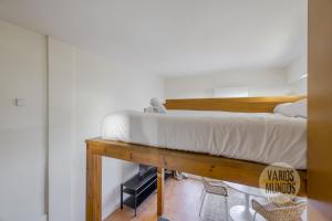 um quarto com uma cama numa mesa de madeira em Fabuloso Atico Doble Altura para 3pax en Chueca em Madrid