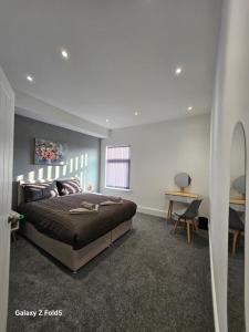 a bedroom with a bed and a desk in it at By the Joyous Stays in Stoke on Trent