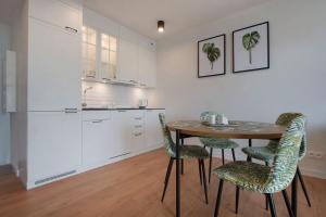 a kitchen with a table and chairs in a room at Apartament Premium Sea View PINEA 704 in Pobierowo
