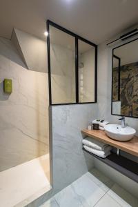 La salle de bains est pourvue d'un lavabo et d'une douche. dans l'établissement Hôtel de la Cité, à Saint-Malo