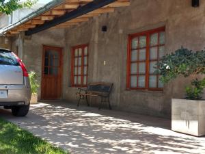 a house with a bench sitting outside of it at Puerta Sur Apart in Malargüe