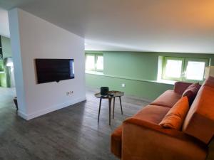 a living room with a couch and a flat screen tv at The Chapman - Central et élégant in Clermont-Ferrand