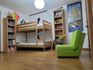 a room with two bunk beds and a green chair at Coloured Studio in Faro