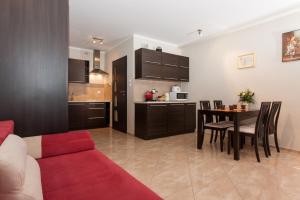 a living room with a red couch and a table at Apartments Świnoujście Center III by Renters in Świnoujście