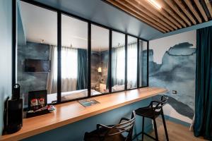 ein Heimbüro mit einem Schreibtisch und Fenstern in der Unterkunft Hôtel de la Cité in Saint-Malo