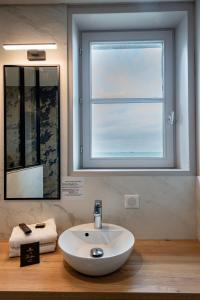 baño con lavabo y ventana en Hôtel de la Cité, en Saint-Malo