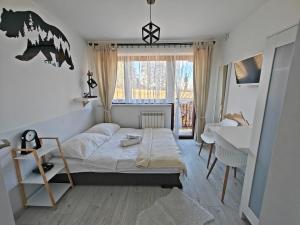 1 dormitorio con cama, escritorio y ventana en Sprawdź nas na WillaBukovinka pl- bliskość lasu, wyciągów i term, atrakcje dla dzieci, ZNIŻKI NA wyciągi, termy, karczmy i atrakcje, en Bukowina Tatrzańska