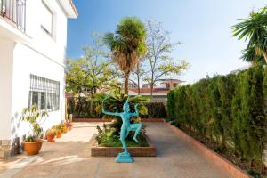 Eine Statue einer Frau, die neben einer Palme steht. in der Unterkunft BBTK Eco-Hostel in Málaga