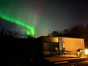 a house with the aurora in the sky at Mesipesa Green Lodge in Laagna