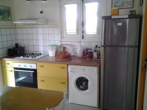 uma cozinha com um frigorífico e uma máquina de lavar roupa em Villa ty gwen em Sainte-Anne