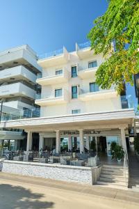 a building with tables and chairs in front of it at Hotel Piccadilly in Bellaria-Igea Marina
