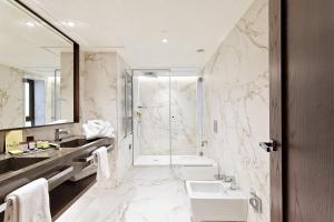 a bathroom with a tub and a sink and a shower at Claridge Madrid in Madrid