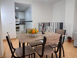 a dining room table with a bowl of fruit and wine glasses at Brisa del Mar - 2 min playa in El Ejido