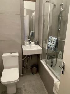 a bathroom with a toilet and a sink and a shower at 10 min to The Heart of London - Zone 2 - Charming 2 bed Apartment in London +32 photos
