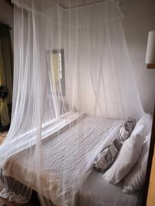 een wit bed met een baldakijn in een slaapkamer bij White Elephant Ella in Ella