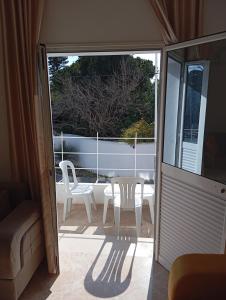een glazen schuifdeur naar een patio met een tafel en stoelen bij Bel appartement proche de la mer Hammamet in Hammamet