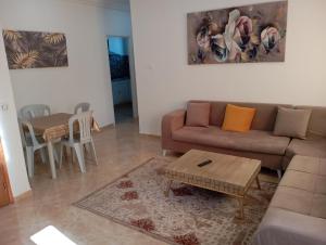 un soggiorno con divano e tavolo di Bel appartement proche de la mer Hammamet a Hammamet