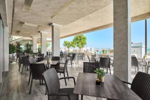 a restaurant with tables and chairs with a view at Hotel Piccadilly in Bellaria-Igea Marina